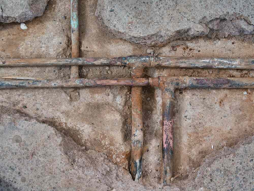 corroded pipes beneath concrete