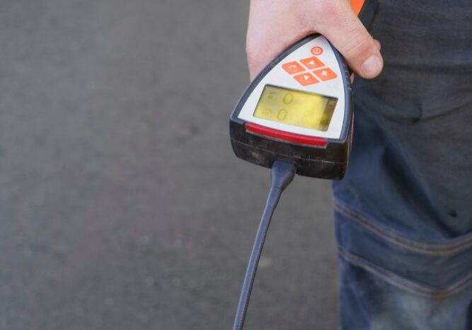 An advanced acoustic listening device placed on a tiled floor to precisely locate a plumbing leak beneath a concrete foundation slab.